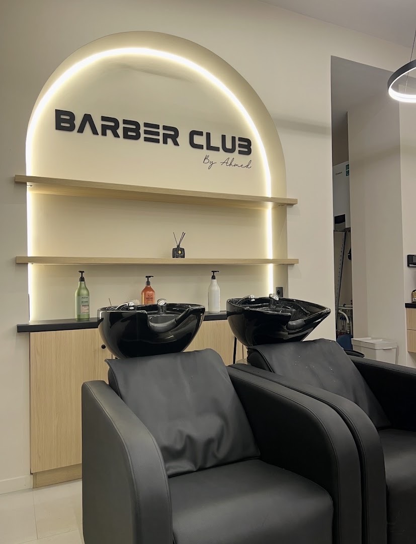 Bacs à shampoing sous l'arche lumineuse au logo Barber Club
