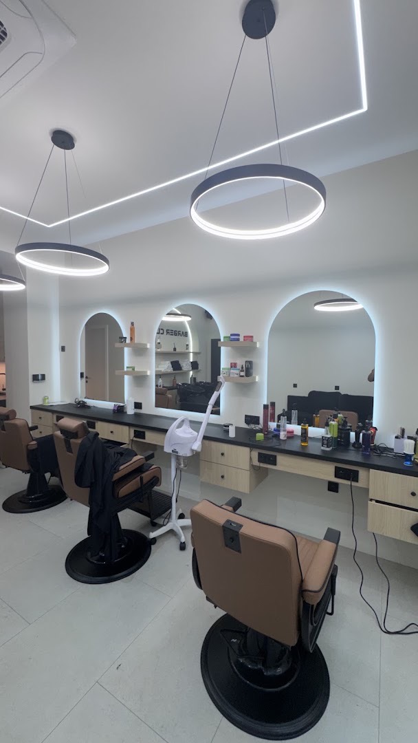 Le salon Barber Club : fauteuils en cuir et miroirs en arche éclairés